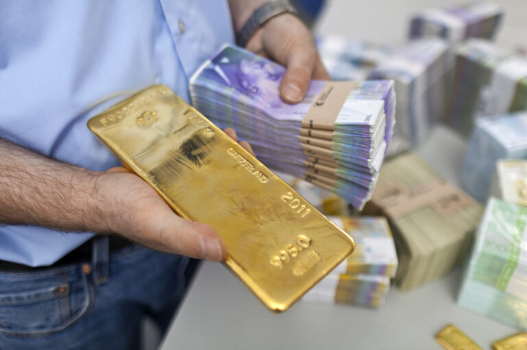 Bundles of bank notes of 1000 Swiss Francs and a gold bar at the bank vault of the 