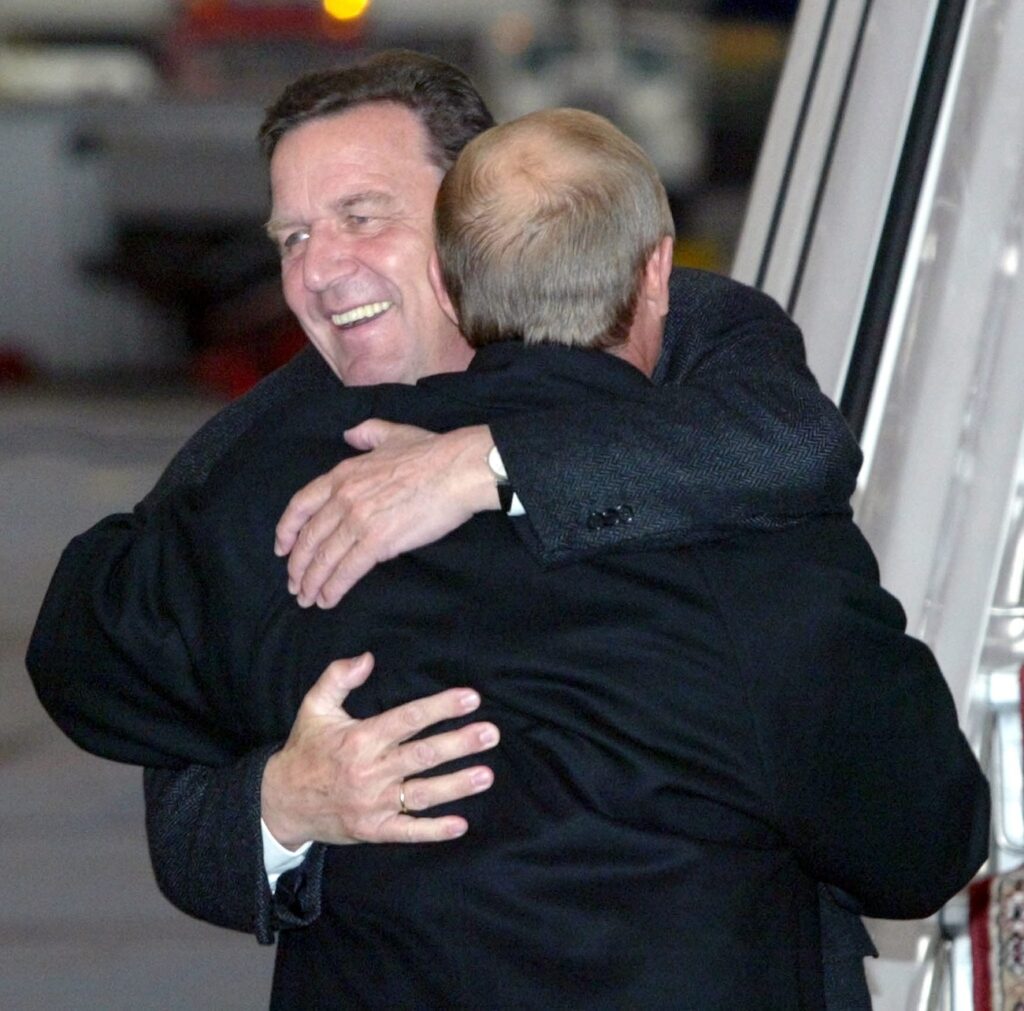 Russian President Vladimir Putin (back to camera) hugs German Chancellor Gerhard Schroeder as Schroeder arrives at the airport of Yekaterinburg, Russia, on Wednesday, 08 October 2003. The two leaders are expected to discuss intergovernmental affairs and economic issues during the upcoming sixth Russian-German summit. (KEYSTONE/EPA/POOL/SERGEI ILNITSKY)