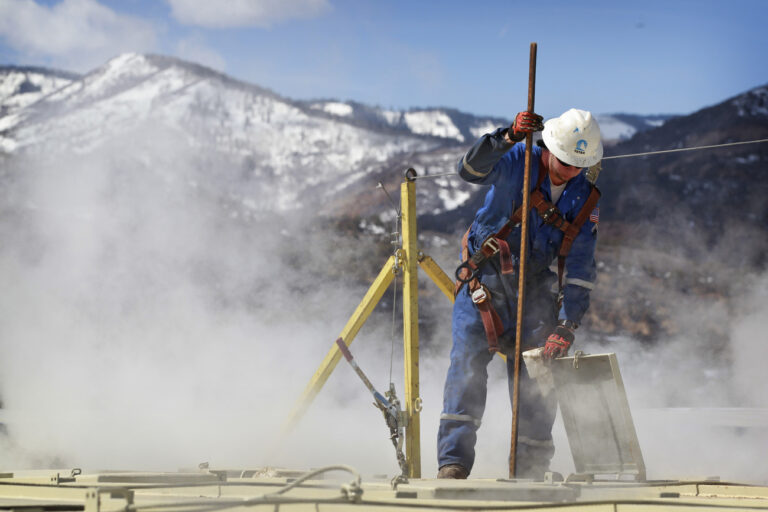 In this March 29, 2013 photo, a worker checks a dipstick to check water levels and temperatures in a series of tanks at an Encana Oil & Gas (USA) Inc. hydraulic fracturing operation at a gas drilling site outside Rifle, Colorado. Hydraulic fracturing, or “fracking,” can greatly increase the productivity of an oil or gas well by splitting open rock with water, fine sand and lubricants pumped underground at high pressure. Companies typically need several million gallons of water to frack a single well. In western Colorado, Encana says it recycles over 95 percent of the water it uses for fracking to save money and limit use of local water supplies. (AP Photo/Brennan Linsley)