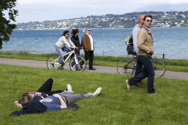 People lie on the grass enjoying the sunshine at the Perle du Lac on the bank of the lake of Geneva, in Geneva, Switzerland, Sunday, June 2, 2013. (KEYSTONE/Salvatore Di Nolfi)