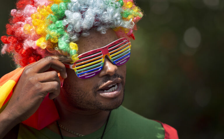 A protester wears a rainbow-colored wig and glasses as Kenyan gays and lesbians and others supporting their cause stage a rare protest, against Uganda's increasingly tough stance against homosexuality and in solidarity with their counterparts there, outside the Uganda High Commission in Nairobi, Kenya Monday, Feb. 10, 2014. Homosexuality has been criminalized in Uganda where lawmakers have recently passed a new bill, which appears to have wide support among Ugandans, that prescribes life imprisonment for 