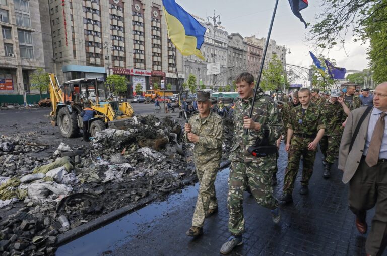 epa04176956 Maydan's self-defense members march as Ukrainian communal workers remove a barricade near Independence Square in Kiev, Ukraine, 23 April 2014. Russia warned on 23 April that it would send troops to Ukraine if its citizens come under attack there. 