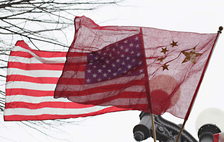 FILE - In this Jan. 17, 2011 file photo, American and Chinese flags fly along Pennsylvania Avenue in front of the White House in Washington. The Justice Department's indictment last week of five Chinese military officials charged them with trying to pilfer confidential information from American companies. But even some of the alleged U.S. corporate victims of the hackers have little incentive to cheer any trade rupture with China. (AP Photo/Carolyn Kaster, File)