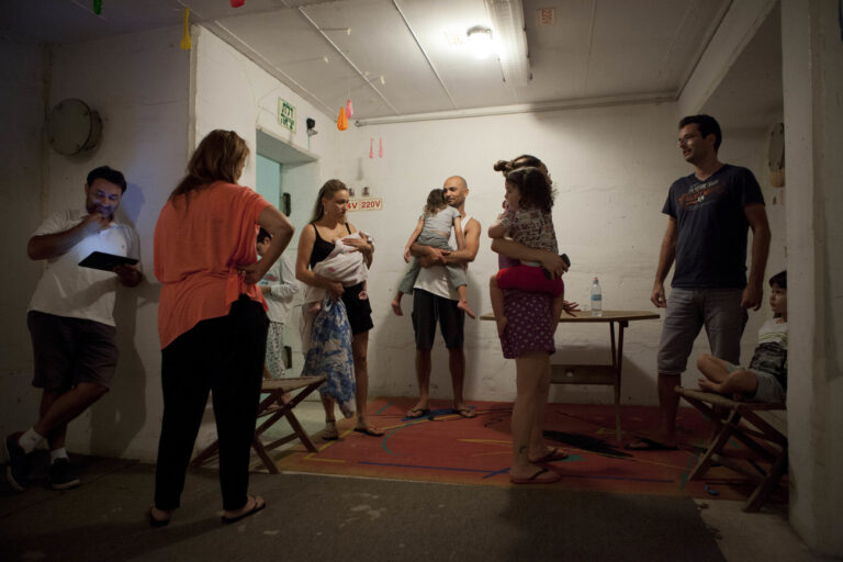 Israelis take cover in shelter as a siren sounds during a rocket attack fired by Palestinian militants from Gaza, in Tel Aviv, Israel, Saturday, July 12, 2014. Israel's prime minister vowed Friday to press forward with a broad military offensive in the Gaza Strip, insisting international pressure will not halt what he said was a determined effort to halt rocket fire by Palestinian militants as the death toll from the 4-day-old conflict rose above 100. (AP Photo/Dan Balilty)