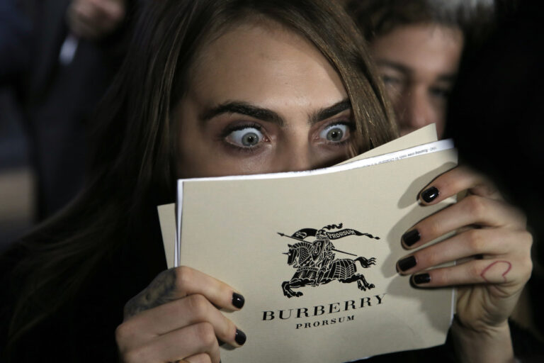 British model Cara Delevingne reacts as she attends a festive launch to mark the collaboration between top Paris department store Printemps and British fashion brand Burberry, in Paris, France, Thursday, Nov. 6, 2014. (AP Photo/Francois Mori)