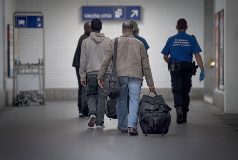 Ein Angehoeriger des Grenzwachtkorps, rechts, fuehrt angekommene Migranten am Zoll des Bahnhofs Chiasso zur Zollkontrolle, aufgenommen am Samstag, 20. Juni 2015. In den vergangenen Tagen sind ueberdurchschnittlich viele Asylsuchende in die Schweiz gelangt. Im Empfangs- und Verfahrenszentrum Chiasso kam es deswegen zu Engpaessen. (KEYSTONE/Ti-Press/Pablo Gianinazzi)