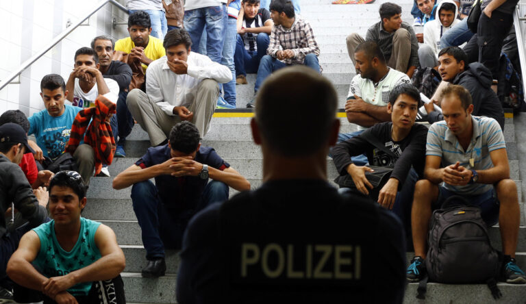 Refugees wait for their registration after arriving Germany at the main station in Rosenheim, Germany, Tuesday, July 28, 2015. Thousands of refugees arrived in the border region between Austria and Germany in the last few weeks. (AP Photo/Matthias Schrader)