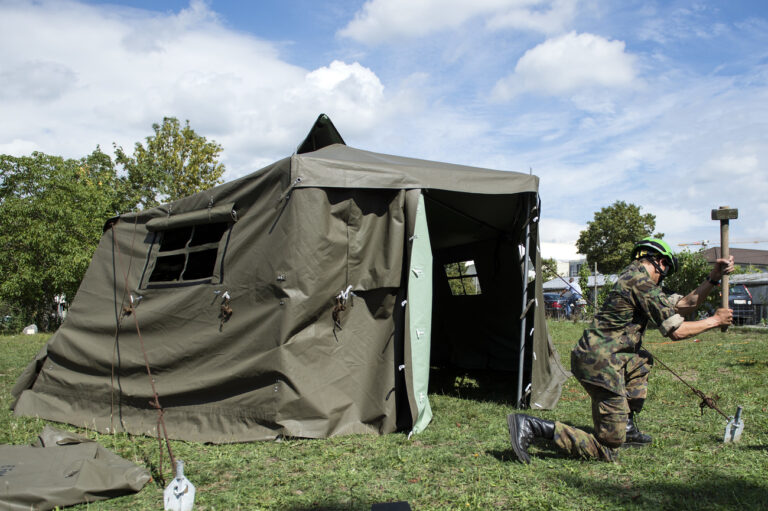 Angehoerige der Armee stellen Zelte zur voruebergehenden Unterbringung von Asylsuchenden auf, am Mittwoch, 2. September 2015, in Lyss. (KEYSTONE/Peter Schneider)