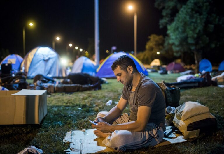 epa04936359 A refugee uses his mobile phone as he rests at a gas station in Beli Manastir, north-eastern Croatia, near the Hungarian border, 18 September 2015. The small north-eastern Croatian stretch between Serbia and Hungary has become the latest flashpoint in Europe's refugee crisis as migrants sought alternative routes to Western Europe after Hungary slammed its doors shut. Hungary on 15 September sealed the last gap in the barricade along its border with Serbia, closing the passage to thousands of refugees and migrants still waiting on the other side and some groups decided to pass over Croatia. EPA/BALAZS MOHAI HUNGARY OUT