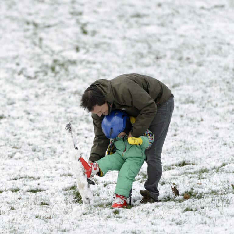 Un pere et son fils Romero l'aide a faire du ski, ce dimanche 17 janvier 2016 a Geneve. La neige a refait son apparition jusque en plaine dans la matinee. (KEYSTONE/Martial Trezzini)