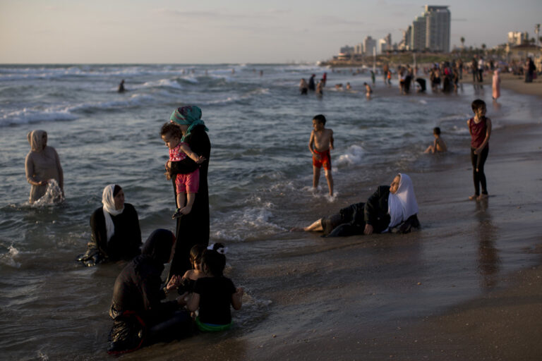 Israeli Arabs enjoy the Mediterranean sea during the Eid al-Fitr holiday, in Tel Aviv, Israel, Friday, July 8, 2016. Eid al-Fitr marks the end of the Muslim holy fasting month of Ramadan. (AP Photo/Oded Balilty)