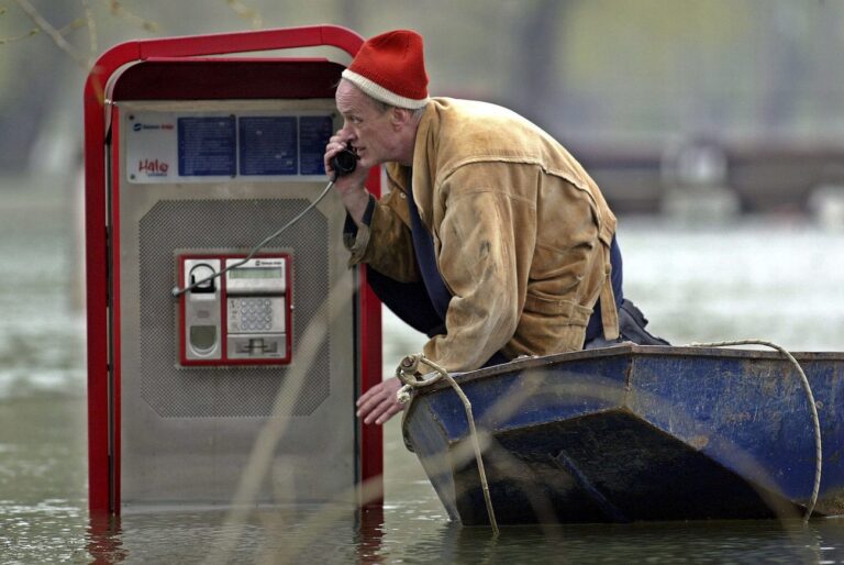 A man checks a public phone placed at the flooded promenade on the Sava river bank in Belgrade, on Thursday 06 April 2006. Water levels of Serbian rivers, especialy Danube, continued to rise and caused a state of emergency in the northern and central regions of the country most affected by the flooding. (KEYSTONE/EPA/Sasa Stankovic)