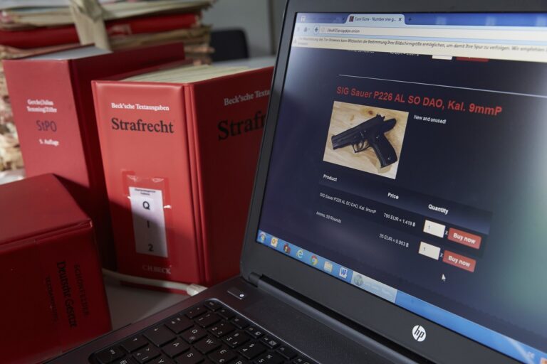 Webseite mit Schusswaffe im Darknet, angezeigt auf dem Laptop-Bildschirm, Strafrecht-Buecher, Deutschland. Laptop screen, Darknet firearms website, criminal law books, Germany (KEYSTONE/imageBROKER/Thomas Frey)