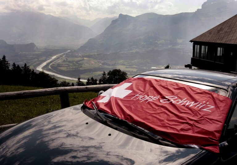 Die Fussball WM in Deutschland ist vorbei, und die Fans koennen ihre Flaggen wieder fuer profanere Dinge benuetzen, zum Beispiel als Sonnenschutz fuers Auto, wie hier oberhalb von Triesenberg, am Mittwoch, 12. Juli 2006, mit Blick ins Sarganserland. (KEYSTONE/Eddy Risch)