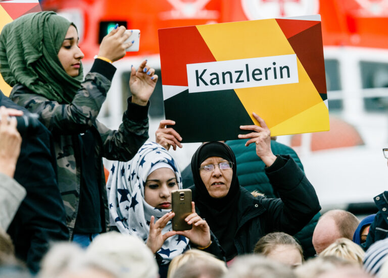 Eine Frau mit Kopftuch hält am 20.09.2017 in Kappeln (Schleswig-Holstein) während einer Wahlkampfveranstaltung zur Bundeswahl mit Bundeskanzlerin Merkel ein Plakat mit der Aufschrift «Kanzlerin» in die Höhe. (KEYSTONE/DPA/Markus Scholz)