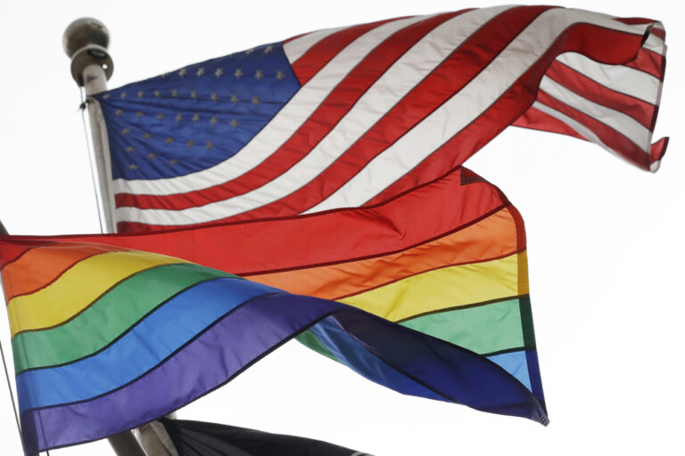 The Rainbow Flag flies beneath the American flag at the Stonewall National Monument, Wednesday, Oct. 11, 2017, in New York. The Rainbow Flag, an international symbol of LGBT liberation and pride, was flown for the first time at the monument. (AP Photo/Mark Lennihan)