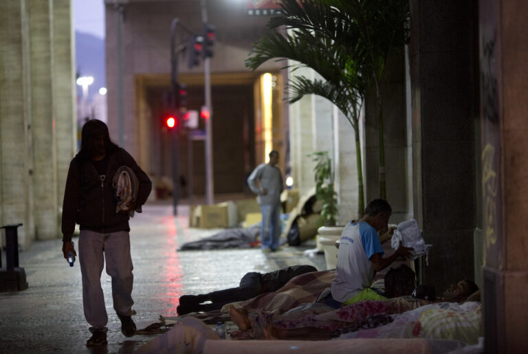 In this Friday, Dec. 8, 2017 photo, homeless sleep in the streets in Rio de Janeiro, Brazil. While many U.S. cities have experienced sharp increases in people living outdoors thanks to rising housing prices amid a recovering economy, in Rio the driving factors have been fallout from Brazil's worst recession in decades, coupled with long-standing inequalities. (AP Photo/Silvia Izquierdo)