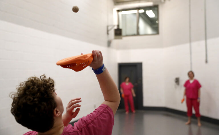 In this March 15, 2018 photo, inmate Danielle Hale uses a sandal to play a modified tennis game with cellmates at the Campbell County Jail in Jacksboro, Tenn. On their one hour outside their cell, they can visit an exercise room, but it has no equipment so the women improvise. (AP Photo/David Goldman)