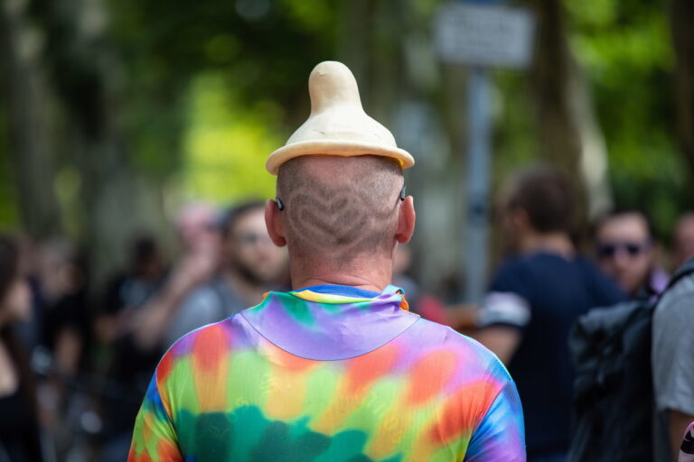 epa06971242 A participant wears a hat shaped like a condom during the 2018 'Zug der Liebe' (Train of Love) parade in Berlin, Germany, 25 august 2018. The 'Train of Love' is a large happening of music and street dancing calling for more compassion, more charity and social commitment. EPA/Omer Messinger