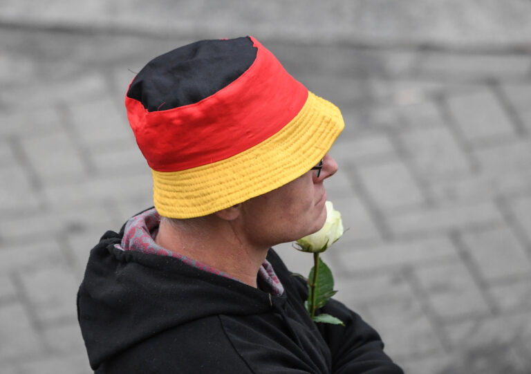 01.09.2018, Sachsen, Chemnitz: Ein Teilnehmer der Demonstration von AfD und dem ausländerfeindlichen Bündnis Pegida, der sich auch die Teilnehmer der Kundgebung.. der rechtspopulistischen Bürgerbewegung Pro Chemnitz angeschlossen haben, trägt einen Anglerhut in den Farben der Flagge der Bundesrepublik Deutschland und eine weiße Rose. Bei den für den 01.09.2018 angekündigten Demonstrationen rechnet die sächsische Polizei mit einer hohen Zahl von Teilnehmern. Foto: Ralf Hirschberger/dpa +++ dpa-Bildfunk +++ (KEYSTONE/DPA/Ralf Hirschberger)