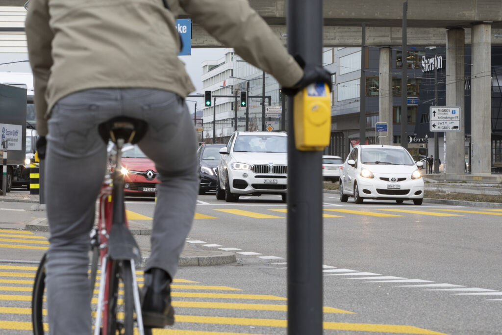 A cyclist and cars waits for green light at the intersection Pfingstweidstrsase and Duttweilerstrasse in Zurich, Switzerland, on March 4, 2019. (KEYSTONE/Gaetan Bally)