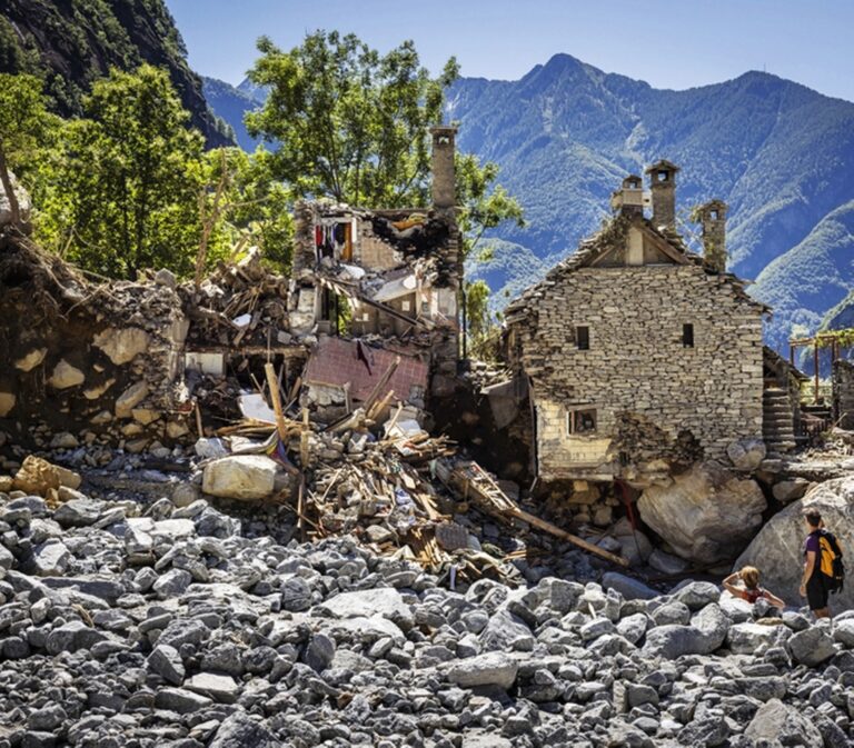 People inspect destroyed houses in a massive landslide in Fontana, in Val Bavona in the Maggia Valley, southern Switzerland on Thursday July 4, 2024. Severe storms and torrential rain over the last weekend left five people dead in Switzerland's Val Maggia and its side valleys in Ticino. (KEYSTONE/Michael Buholzer).