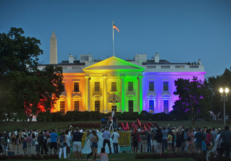 FILE - In this Friday, June 26, 2015 file photo, people gather in Lafayette Park to see the White House illuminated with rainbow colors in commemoration of the Supreme Court's ruling to legalize same-sex marriage in Washington. President Barack Obama, who was inside, said a few days later, 