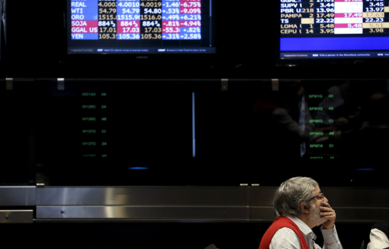 A worker looks at a screen on the floor of the stock market, in Buenos Aires, Argentina, Monday, Aug. 12, 2019. The stock market plumped after a striking victory by the opposition in Sunday's presidential primaries ahead of October's presidential elections. (AP Photo/Natacha Pisarenko)