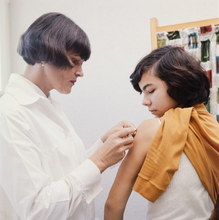 Die Schulaerztin Irena Buxbaum fuehrt im Rahmen ihrer Arbeit im schulaerztlichen Dienst an Jugendlichen eine Impfung gegen Tuberkulose mit dem Impfstoff BCG durch, aufgenommen im November 1970 im Raum Arbon, Kanton Thurgau. (KEYSTONE/PHOTOPRESS-ARCHIV/Fritz Grunder)