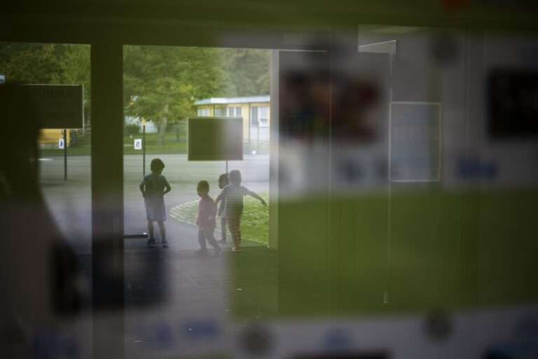 Kinder, die im Hof spielen, spiegeln sich in der Scheibe einer Vitrine im Bundesasylzentrum (BAZ) in Embrach, fotografiert am 31. August 2020. Das Bundesasylzentrum Embrach ist eines der Bundesasylzentren des Staatssekretariats fuer Migration (SEM) ohne Verfahrensfunktion (mit Warte- und Ausreisefunktion). In diesen Bundesasylzentren halten sich ueberwiegend Personen auf, deren Asylverfahren unter das Dublin-Abkommen faellt oder deren Asylgesuch abgelehnt wurde. (KEYSTONE/Christian Beutler)