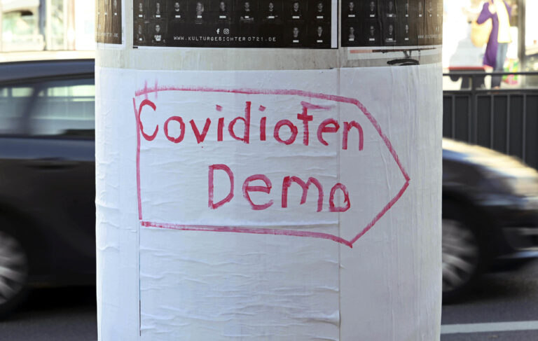 14.11.2020, Baden-Württemberg, Karlsruhe: Auf einer Plakatsäule steht der Schriftzug ·Covidioten Demo·. Unweit davon findet eine 