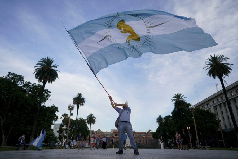 An activist against abortion flies an Argentine flag with a baby painted on it as he protests against the decriminalization of abortion, one day before lawmakers will debate its legalization, at Plaza de Mayo in Buenos Aires, Argentina, Monday, Dec. 28, 2020. (AP Photo/Victor R. Caivano)