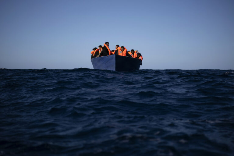 Migrants from Eritrea, Egypt, Syria and Sudan, wait to be assisted by aid workers of the Spanish NGO Open Arms, after fleeing Libya on board a precarious wooden boat in the Mediterranean sea, about 110 miles north of Libya, on Saturday, Jan. 2, 2021. (KEYSTONE/AP Photo/Joan Mateu)