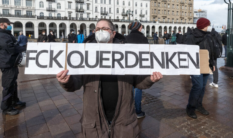 13.03.2021, Hamburg: Eine Gegendemonstrantin hält ein Schild mit der Aufschrift 