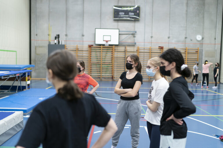 Schuelerinnen der Klassen 4b und 4c der Kantonsschule Wiedikon, KWI, folgen Masken tragend der Ausfuehrungen ihrer Lehrerin, nicht im Bild, fotografiert waehrend des Sportunterrichts am 18. Maerz 2021 in Zuerich. (KEYSTONE/Gaetan Bally)