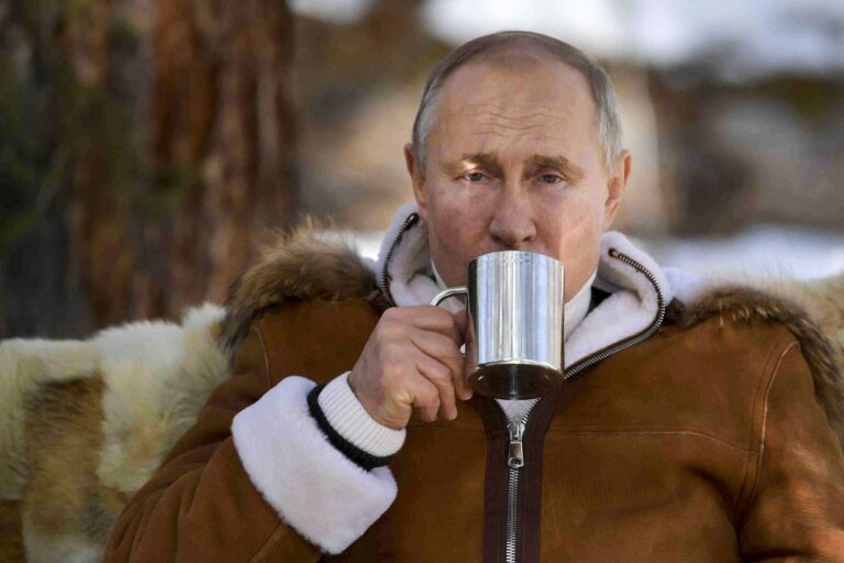 In this photo made available on Sunday, March 21, 2021, Russian President Vladimir Putin drinks during a brake in a taiga forest in Russia's Siberian region in Russia. Putin and Russia Defense Minister Sergei Shoigu are spending this weekend in Siberia, said Kremlin spokesman Dmitry Peskov. (Alexei Druzhinin, Sputnik, Kremlin Pool Photo via AP)