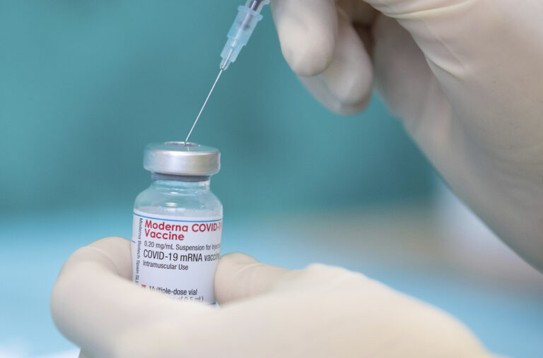 A nurse draws up the vaccine of the manufacturer Moderna against the coronavirus with a syringe in a posed situation a the vaccination centre in Bielefeld, Germany, Friday, April 16, 2021. (Friso Gentsch/dpa via AP)