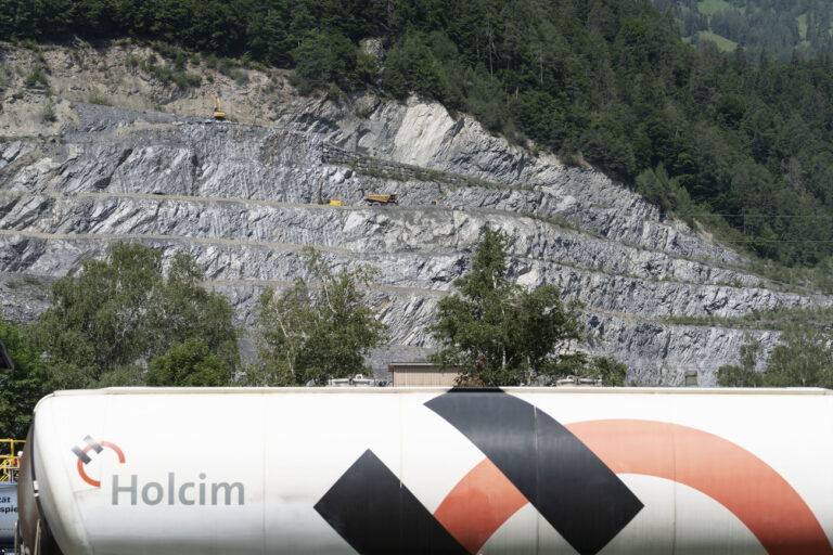 Ein Gueterzug der Firma Holcim im ordergrund und der Steinbruch eines Holcim Zementwerks im Hintergrund, fotografiert am 10. Juni 2021 in Untervaz, Kanton Graubuenden. (KEYSTONE/Gaetan Bally)