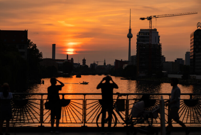 10.07.2021, Berlin: Menschen fotografieren den Sonnenuntergang über der Spree von der Oberbaumbrücke aus. Foto: Christophe Gateau/dpa +++ dpa-Bildfunk +++ (KEYSTONE/DPA/Christophe Gateau)