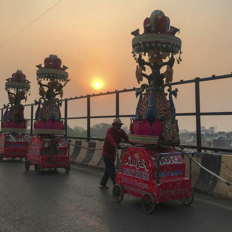 Daily wage laborers carry decorative lights for a marriage procession in Prayagraj, in the northern Indian state of Uttar Pradesh, Saturday, Nov. 27, 2021. (AP Photo/Rajesh Kumar Singh)