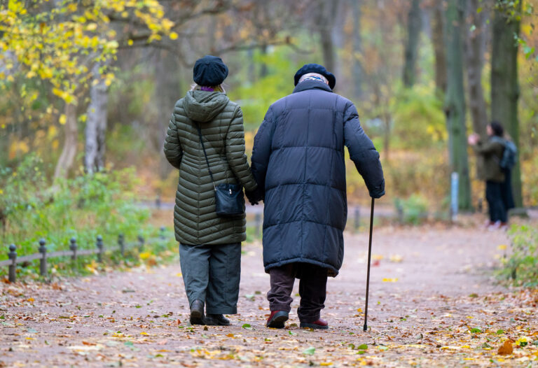 ARCHIV - 19.11.2021, Berlin: Ein älterer Mann mit einem Gehstock und seine Begleitung spazieren durch den Tiergarten. Die rund 21 Millionen Rentnerinnen und Rentner in Deutschland müssen damit rechnen, dass die Rentenerhöhung nächstes Jahr doch etwas geringer ausfallen wird als erwartet. Foto: Monika Skolimowska/dpa-Zentralbild/dpa +++ dpa-Bildfunk +++ (KEYSTONE/DPA/Monika Skolimowska)