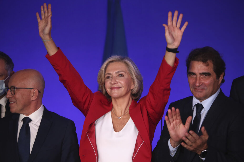 Valerie Pecresse raises her arms at the Conservative party Les Republicains headquarters after being elected as the party's presidential candidate, Saturday, Dec. 4, 2021 in Paris. The head the Paris region, Valerie Pécresse, was facing a hardline lawmaker Eric Ciotti, left, in the final round of The Republicans' primary. At right is party chief Christian Jacob. The first round of the 2022 French presidential election will be held on April 10 2022 and the second round on April 24, 2022. (AP Photo/Rafael Yaghobzadeh)