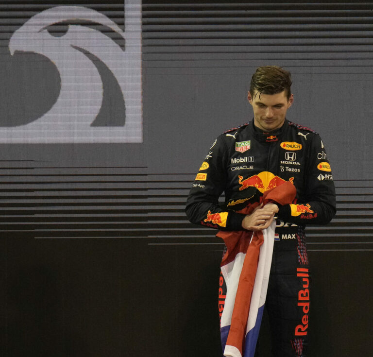 Red Bull driver Max Verstappen of the Netherlands stand on the podium after he became the world champion after winning the Formula One Abu Dhabi Grand Prix in Abu Dhabi, United Arab Emirates, Sunday, Dec. 12, 2021. (AP Photo/Hassan Ammar)