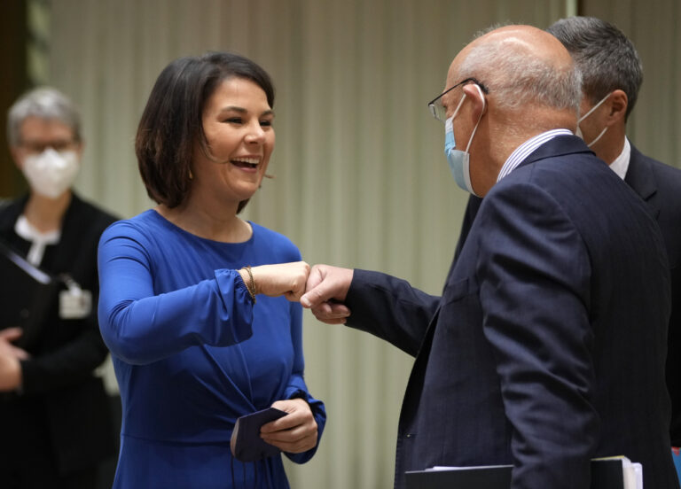Portugal's Foreign Minister Augusto Santos Silva, right, greets German Foreign Minister Annalena Baerbock during a meeting of EU foreign ministers at the European Council building in Brussels on Monday, Dec. 13, 2021. European Union foreign ministers met Monday to discuss how to thwart the threat of a possible new Russian invasion of Ukraine and what measures to take should Moscow decide to send its troops across the border. (AP Photo/Virginia Mayo)