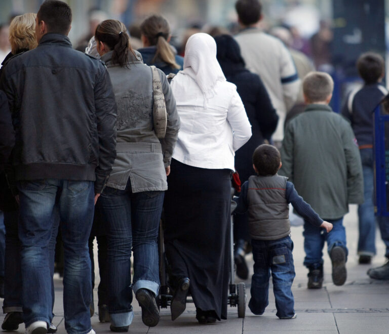 Eine muslimische Frau mit Kopftuch geht am Dienstag, 12. Februar 2008, zwischen Passanten durch die Innenstadt in Duisburg. Bundesinnenminister Wolfgang Schaeuble hat den tuerkischen Ministerpraesidenten Recep Tayyip Erdogan gegen massive Kritik in Deutschland verteidigt. Er habe keinen Grund zur Klage, sagte der CDU-Politiker der 