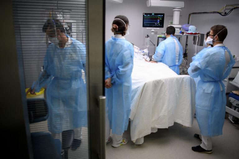 Medical workers treat a patient with COVID-19 in the intensive care unit (ICU) at the University Hospital (CHUV) during the fifth wave of the coronavirus disease (COVID-19) pandemic, in Lausanne, Switzerland, Monday, December 20, 2021. (KEYSTONE/Laurent Gillieron)