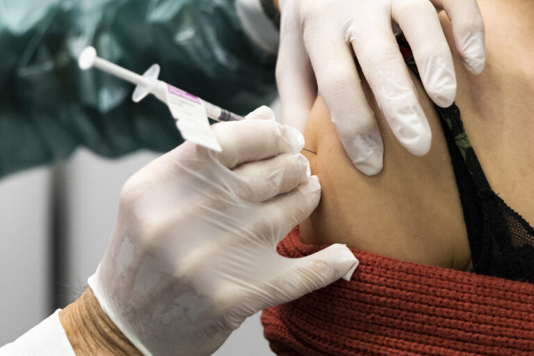 Ein Mitarbeiter des Impfzentrums impft eine Frau, im Walk-In Impfzentrum auf dem BEA-Expo-Gelaende, am Dienstag, 21. Dezember 2021, in Bern. (KEYSTONE/Peter Klaunzer)
