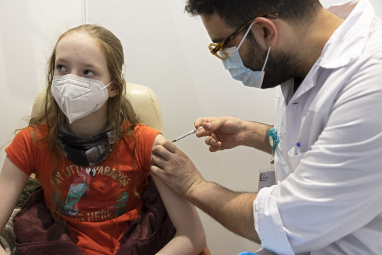 Lilla, 11 year-old, receives a dose of the COVID-19 Pfizer vaccine at the vaccination center of the Geneva University Hospitals (HUG), in Geneva, Switzerland, Wednesday, January 5, 2022. French part of Switzerland started vaccinating children aged between five and eleven. (KEYSTONE/Salvatore Di Nolfi)