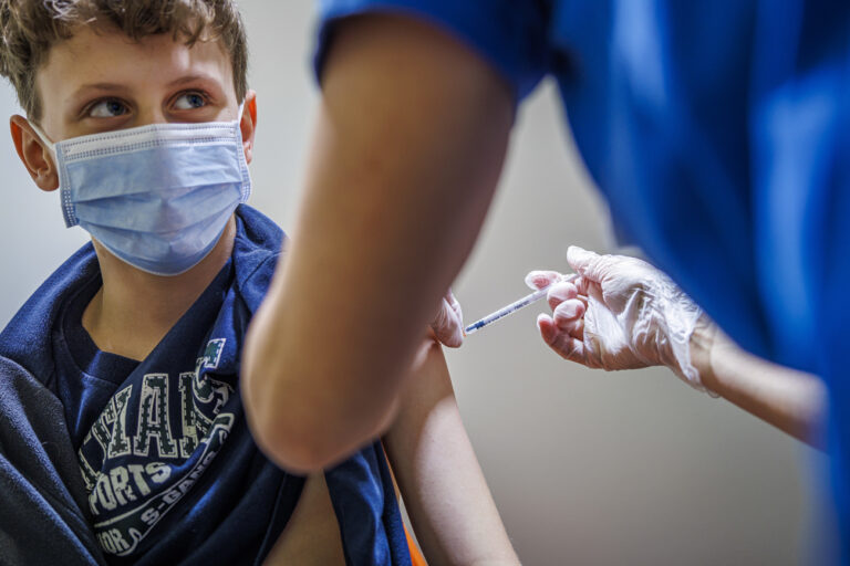 Un enfant recoit une dose de vaccin lors de la premiere journee ouverte a la vaccination contre le COVID-19 pour les enfants des 5 ans, ce samedi 8 janvier 2022 au centre de vaccination de la Chaux-de-Fonds. (KEYSTONE/Valentin Flauraud)..