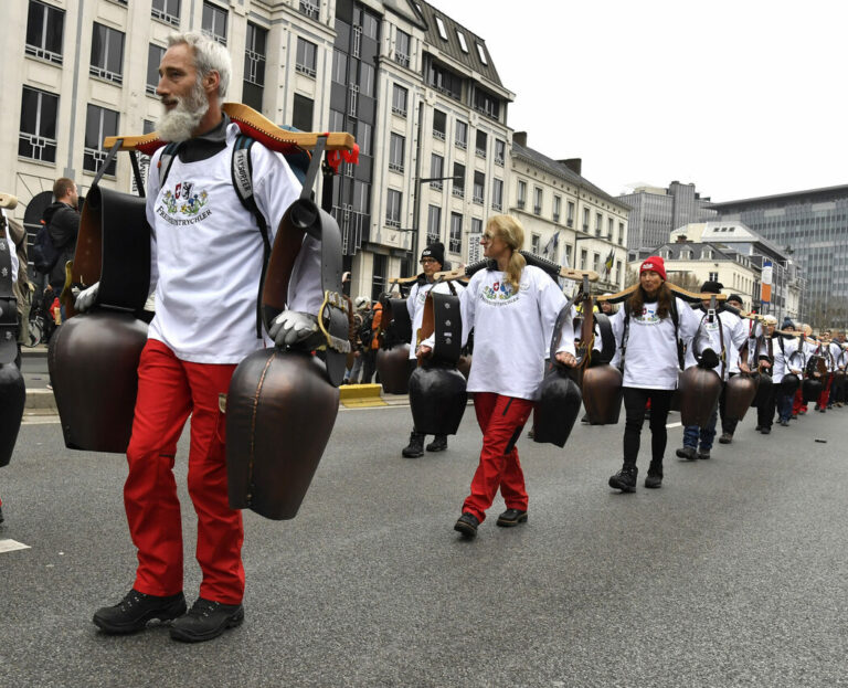 A group marches with bells during a demonstration against COVID-19 measures in Brussels, Sunday, Jan. 23, 2022. Demonstrators gathered in the Belgian capital to protest what they regard as overly extreme measures by the government to fight the COVID-19 pandemic, including a vaccine pass regulating access to certain places and activities and possible compulsory vaccines.(AP Photo/Geert Vanden Wijngaert)